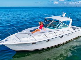 A woman relaxes on the deck of a luxurious yacht, soaking up the sun against a stunning ocean backdrop — perfect for a day of leisure on the water.