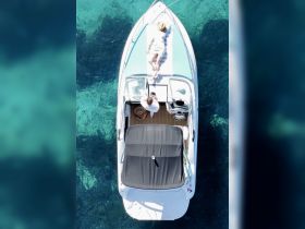 A couple enjoys a relaxing day on a boat, sunbathing on a clear turquoise sea — the perfect getaway for leisure and romance.