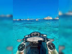 A close-up view of a Sea-Doo jet ski in crystal-clear waters, surrounded by various boats, perfect for thrilling water adventures.
