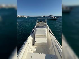 A clear view of a speedboat docked in calm waters, showcasing its sleek design and inviting atmosphere for a day on the water.