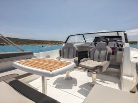 A stylish interior view of a boat's helm and seating area, showcasing comfortable chairs and a sleek design — perfect for relaxing while cruising on the water.