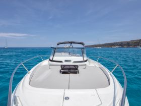 A stunning view of a speedboat cruising through crystal-clear turquoise waters, showcasing the boat's sleek design and inviting atmosphere for a day on the water.