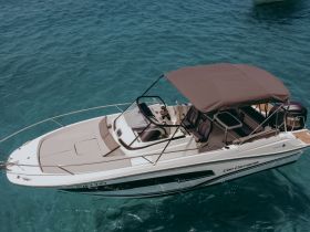 Aerial view of a sleek center console boat cruising through crystal-clear waters, perfect for day trips and water adventures.