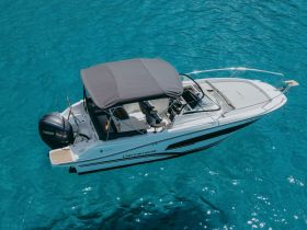 A stunning aerial view of a sleek speedboat cruising through crystal-clear turquoise waters, perfect for exploring coastal destinations.