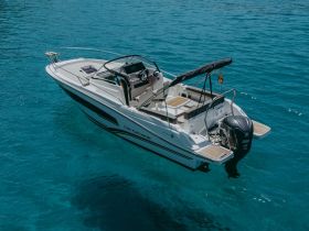 A stunning aerial view of a sleek center console boat cruising through crystal-clear turquoise waters, perfect for day trips and water adventures.