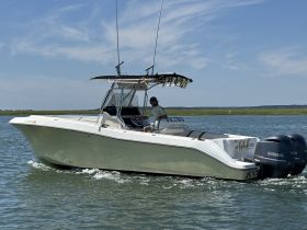 A sleek speedboat navigates through calm waters, showcasing its modern design and powerful Yamaha engines — perfect for thrilling adventures on the water.