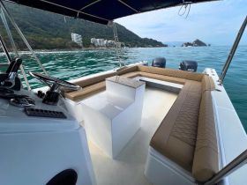 A spacious interior view of a boat's helm and seating area, showcasing comfortable lounge space ideal for relaxing while cruising on the water.
