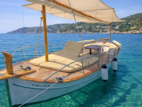 A beautiful sailboat anchored in crystal-clear waters, showcasing its elegant design and inviting deck space, perfect for leisurely outings.