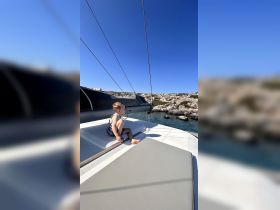 A young child enjoys a moment of relaxation on the deck of a boat, overlooking the serene ocean — a perfect snapshot of family time on the water.