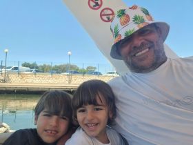 A joyful moment captured with a father and his two children aboard a boat, showcasing family fun and smiles on the water.