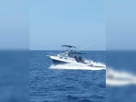 A sleek speedboat navigates through the open ocean, showcasing its design and performance on the water.