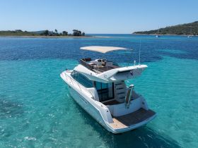 A stunning aerial view of a luxurious yacht cruising through crystal-clear turquoise waters, perfect for summer adventures and island hopping.