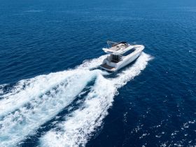 A stunning aerial view of a sleek yacht cruising through deep blue waters, showcasing the elegance and performance of modern boating.
