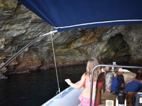A group of children explores a cave while aboard a boat, showcasing the excitement of adventure on the water.