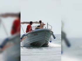 A couple enjoys a scenic ride on a small boat, capturing the essence of adventure on the water.