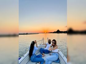 A group of friends captures the stunning sunset from a pontoon boat, creating unforgettable memories on the water.