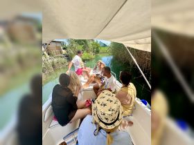 A lively group enjoys a day on the water, surrounded by lush greenery, creating unforgettable memories aboard their boat.