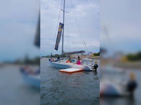 A lively group enjoys a day of sailing, showcasing fun water activities and camaraderie aboard a sleek sailboat.
