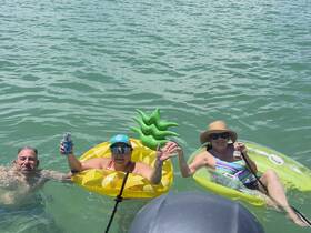 A fun group enjoys a sunny day in the water, floating on inflatable toys and sipping drinks — the perfect recipe for a memorable summer outing.