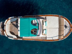 A stunning aerial view of a luxurious yacht showcasing its spacious deck and inviting sunbeds, perfect for relaxing on the open water.