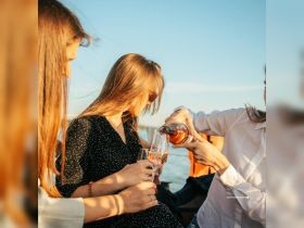A group of friends enjoys a toast with cocktails on a boat, capturing the essence of celebration and camaraderie during a sunset cruise.