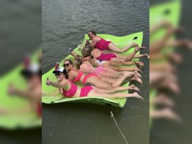 A fun group of friends enjoys a sunny day on a floating mat, showcasing the perfect blend of relaxation and celebration on the water.