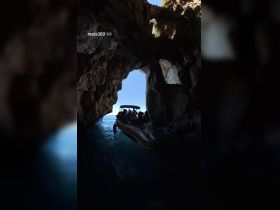 A group of adventurers navigates a boat through a stunning cave, showcasing the thrill of exploration on the water.