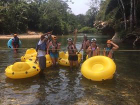 A lively group enjoys tubing in a river, showcasing fun outdoor activities and camaraderie in a beautiful natural setting.