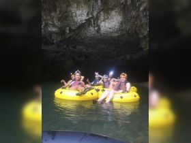 A group of friends enjoys an adventurous tubing experience inside a cave, showcasing the thrill of exploring unique natural formations.
