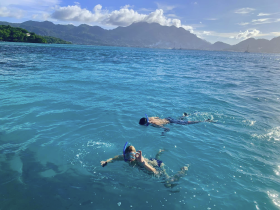 Two children enjoy snorkeling in crystal-clear waters, surrounded by stunning mountain views — a perfect family adventure in the great outdoors.
