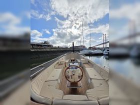 A spacious interior view of a boat's helm and seating area, showcasing elegant design and comfort, perfect for leisurely cruises.