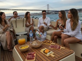 A lively group enjoys cocktails and gourmet snacks aboard a yacht, capturing the essence of a perfect celebration on the water with stunning views.