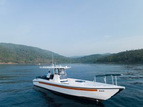 A sleek speedboat named 'ROAA' glides through calm waters, surrounded by lush greenery — perfect for exploring scenic coastlines.