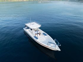 Two individuals relax on a sleek boat, enjoying the serene waters — a perfect scene for a day of leisure on the water.