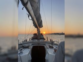A group enjoys a picturesque sunset while sailing, creating a perfect backdrop for memorable moments on the water.