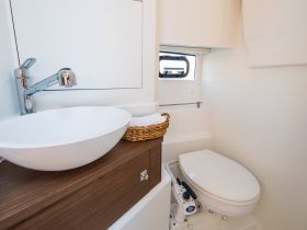 A clean and modern boat bathroom featuring a stylish sink and toilet, perfect for onboard comfort and convenience.