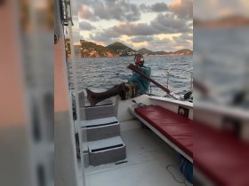A man relaxes on a boat while enjoying the ocean view at sunset, showcasing the perfect blend of leisure and adventure on the water.