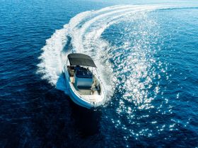 An aerial view of a sleek speedboat gliding through sparkling blue waters, showcasing the thrill of boating adventures.