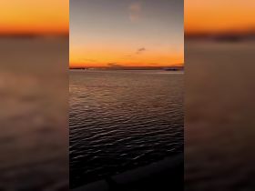 A serene view of a sunset over calm waters, creating a tranquil atmosphere perfect for evening reflections.