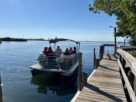 A lively group enjoys a day on a pontoon boat, perfect for socializing and relaxing on the water.