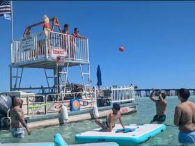 A lively beach scene featuring a group enjoying a game of basketball in the water, with kids and adults participating in the fun — perfect for summer outings and family adventures.