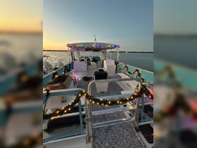 Interior view of a decorated boat showcasing festive lights and seating arrangements, perfect for holiday gatherings on the water.
