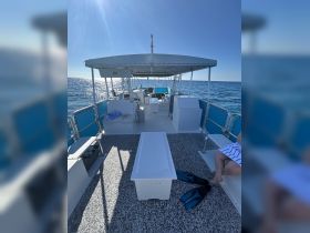 A spacious interior view of a boat featuring seating and helm areas, perfect for relaxing and enjoying the open water.