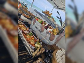 A beautifully arranged charcuterie display featuring a variety of delicious foods, perfect for a wedding celebration on a boat.