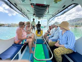 A lively group enjoys a boat ride, engaging in conversation and laughter, showcasing the joy of shared experiences on the water.