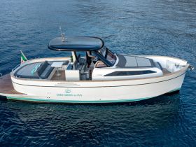 A stunning aerial view of a sleek yacht docked in clear waters, showcasing its elegant design and spacious seating area, perfect for luxury outings.