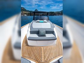 A beautifully designed seating area on a boat, featuring plush cushions and a stylish wooden deck, perfect for relaxing while enjoying the scenic views.