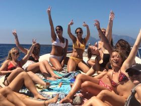 A lively group of friends celebrates on a boat, enjoying the sun and sea — perfect for summer parties and unforgettable memories.
