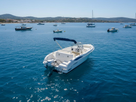 A sleek speedboat anchored in clear blue waters, surrounded by other vessels, perfect for exploring coastal destinations.