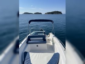 A clean and spacious interior view of a boat's helm and seating area, perfect for enjoying a day on the water with friends or family.